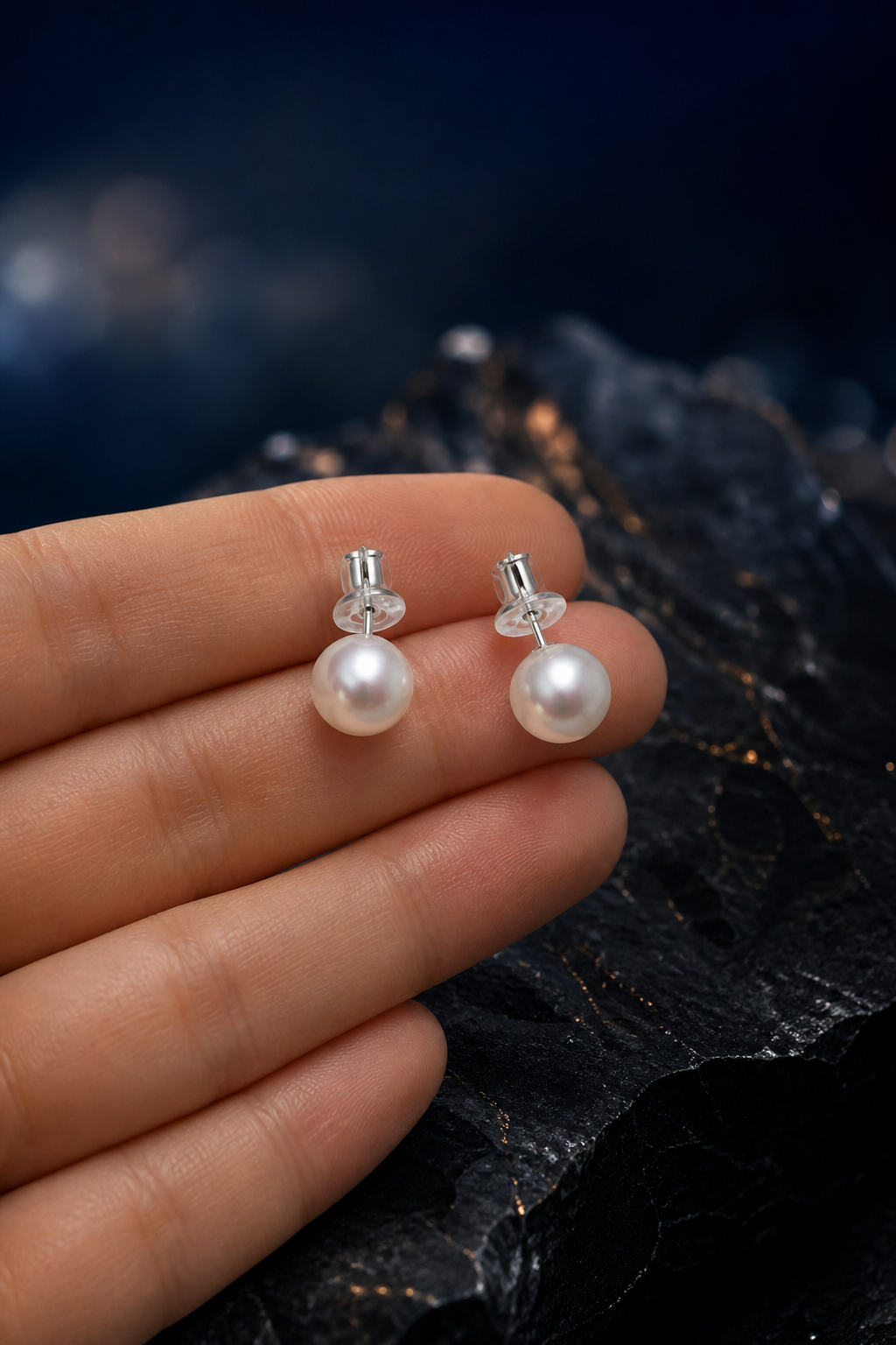 Moondrop Pearl Stud Earrings shown in hand for scale