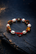 Red Cord Tiger's Eye Pearl Bracelet front view on a dark atmospheric backdrop